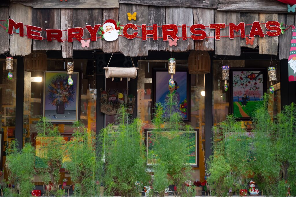 Weihnachten in Thailand mit Merry-Christmas-Dekoration an einem traditionellen Holzgebäude